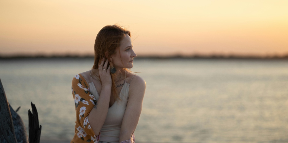 Woman at the beach considering that her bulimia may have turned into an addiction.