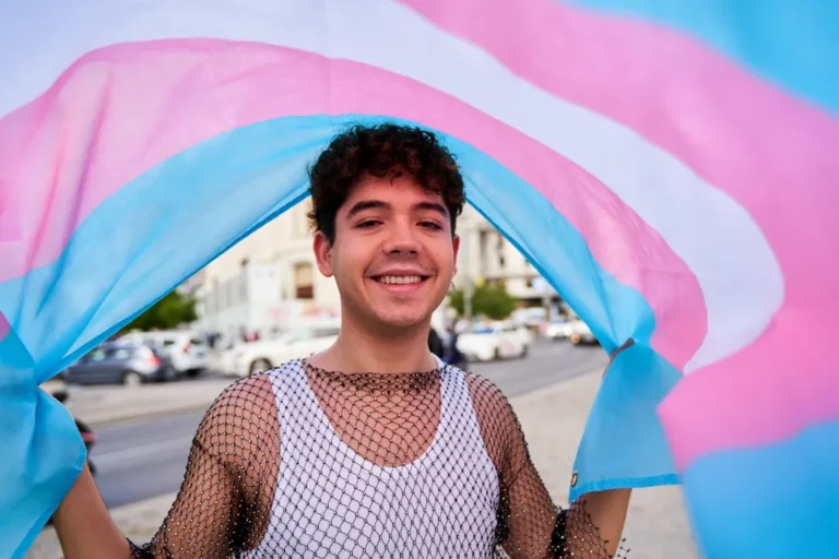 a-man-is-smiling-and-holding-a-trans-flag-the-fla-2026-01-06-09-17-42-utc