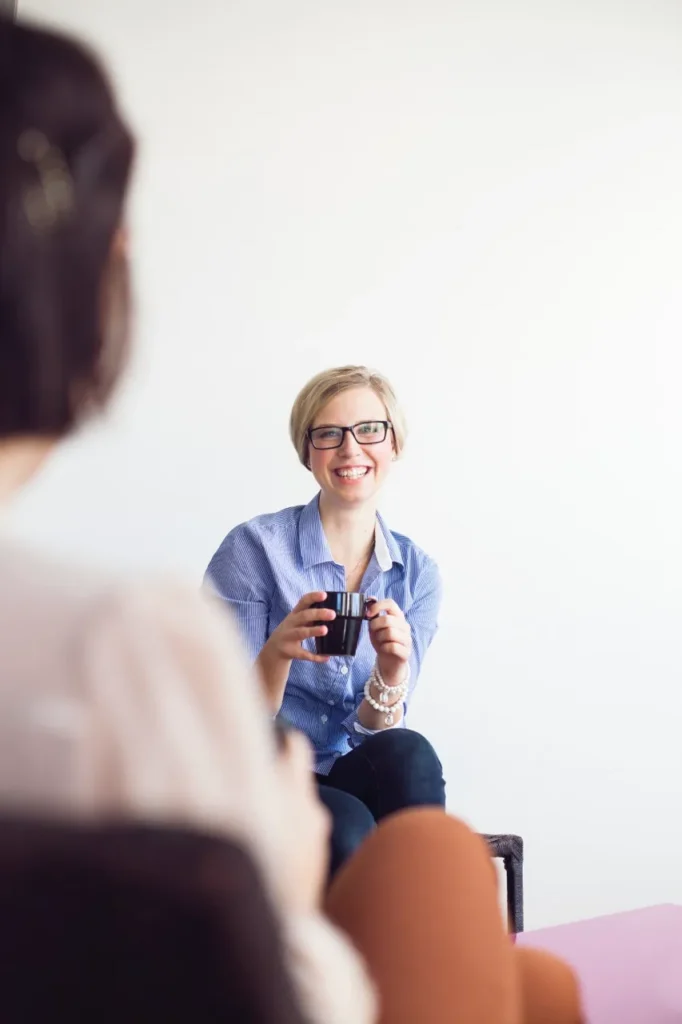 imgi 38 happy businesswoman holding coffee mug while talki 2024 10 15 02 30 44 utc Large - Mental Health Treatment Orange County | We Conquer Together
