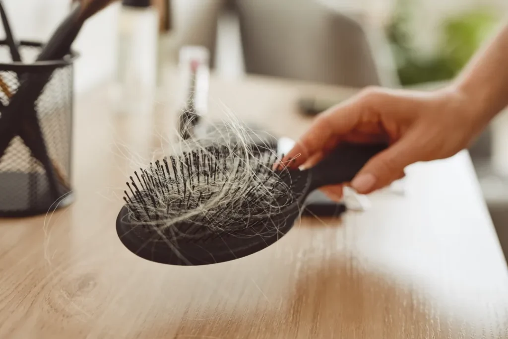 woman finding hair loss from anorexia in a hair brush.