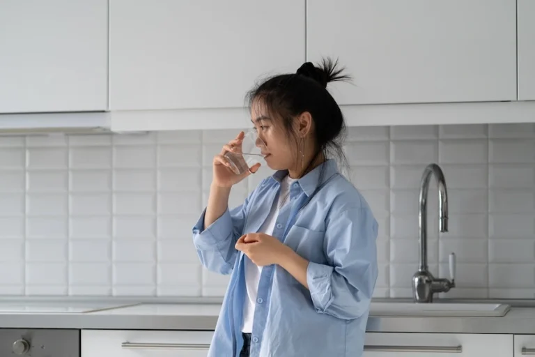 woman-drinking-water-in-minimalist-modern-kitchen-2026-03-19-09-27-12-utc